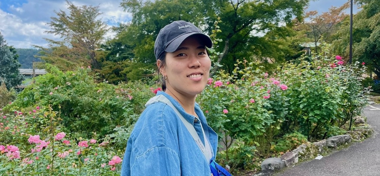 a young woman with a cap smiling at the camera