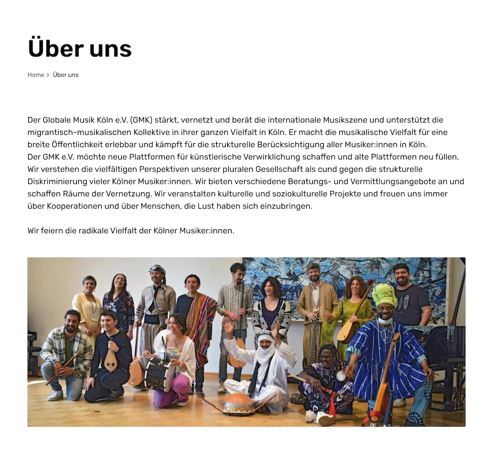 A screenshot of the 'About Us' page in German. There is a title, breadcrumbs, and a long text about Globale Musik. At the bottom, there is a picture of people with various musical instruments.